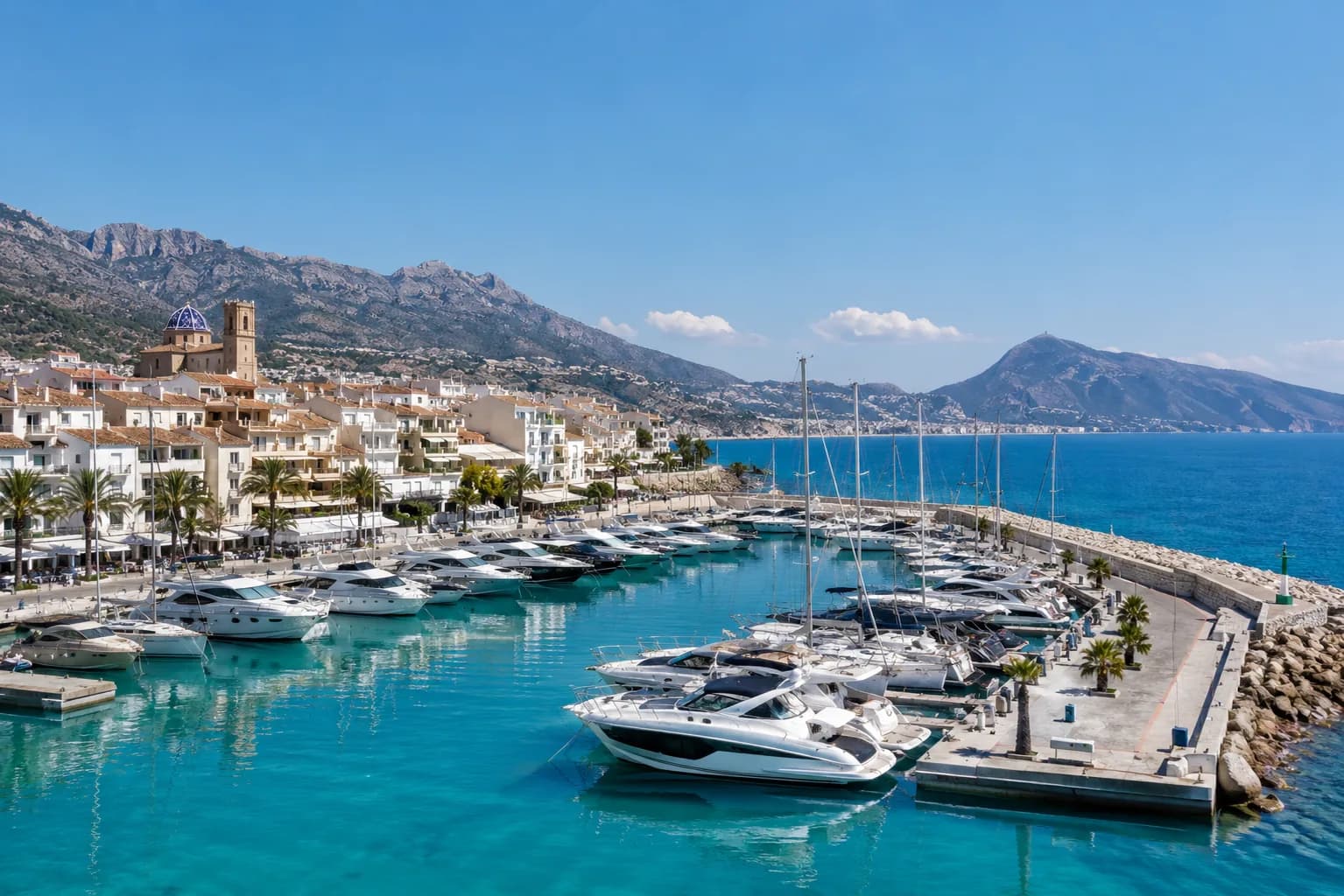 Westliches Mittelmeer, Spanien · Balearen — Mediterrane Küstenbucht mit heller Bebauung über dem Ankerplatz.
