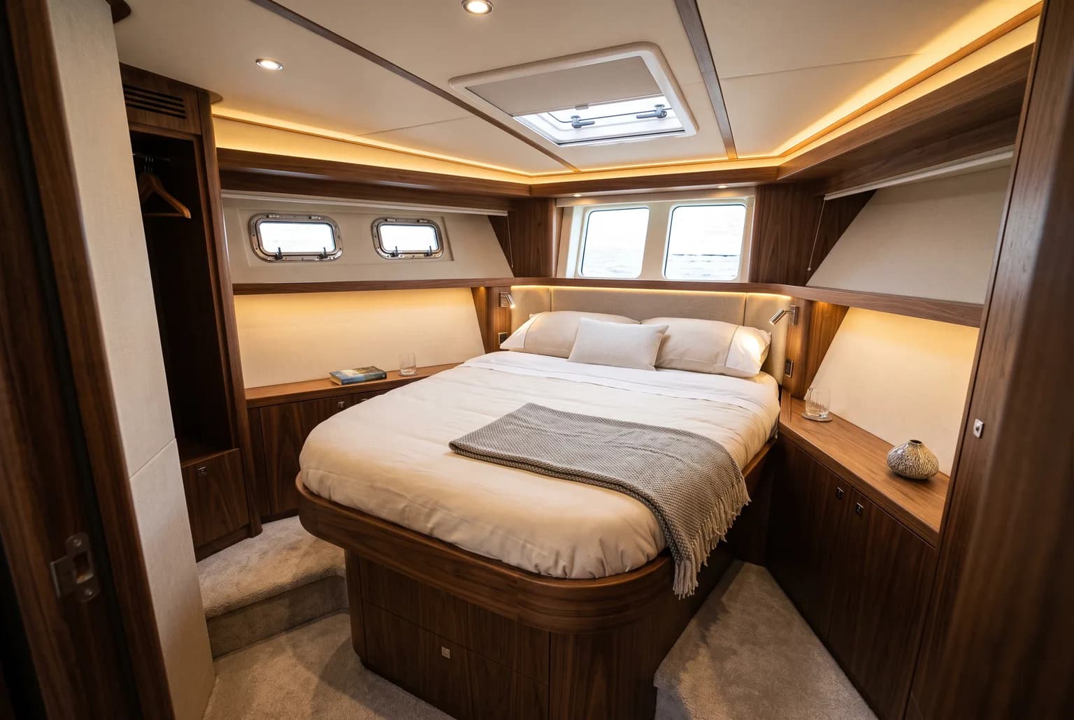 PrimaMare Essential, 12 bis 15 Meter — Eignerkabine mit Doppelbett, Holzverkleidung und Seitenfenstern.